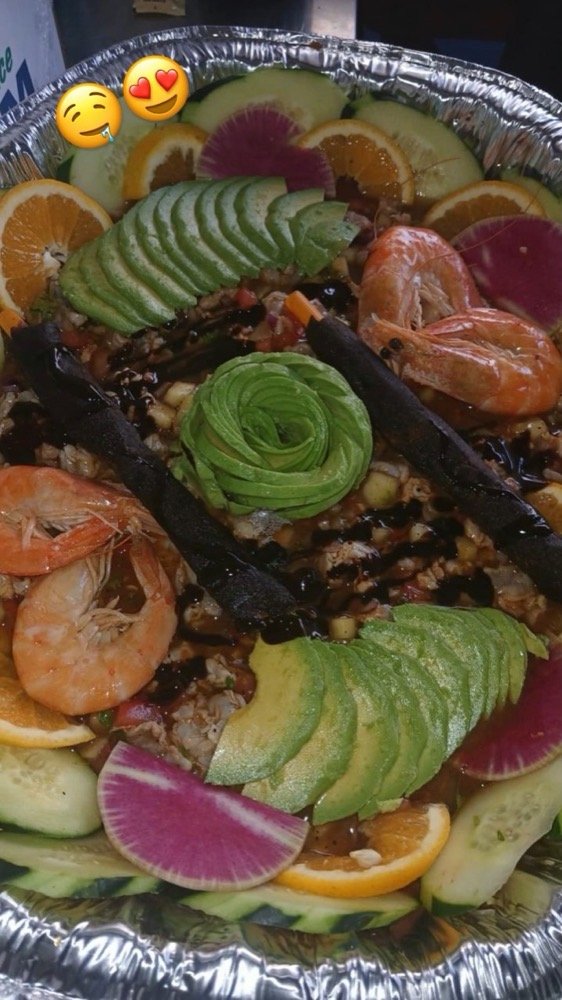 Charola de ceviche con camarones, aguacate en rosa, naranja y salsa negra