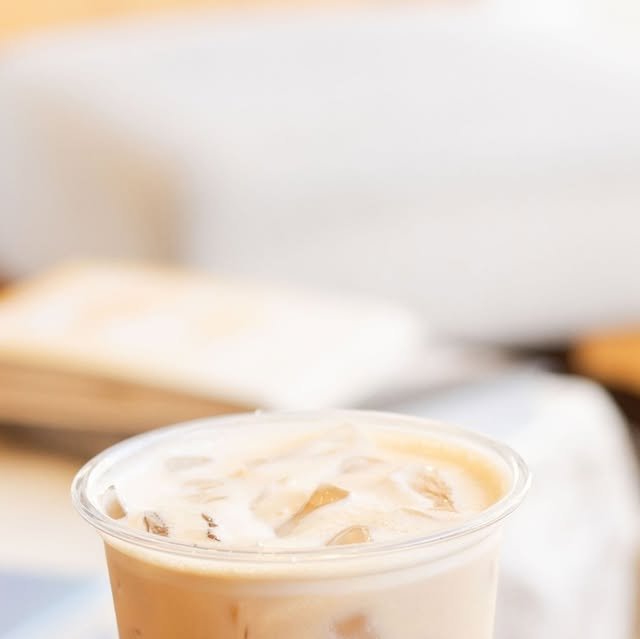 Latte frío de Citadel con hielo y leche cremosa en vaso transparente, con luz de tarde