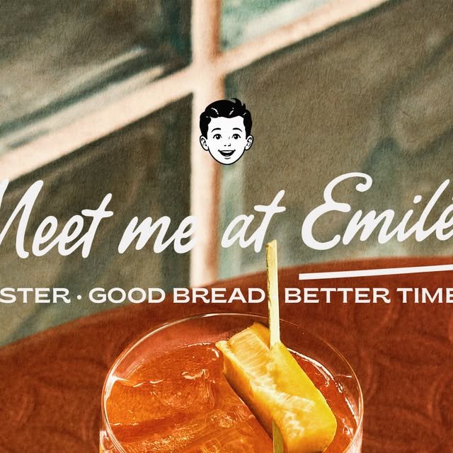 Trago ámbar con fruta en palillo y el letrero Meet me at Emiléo