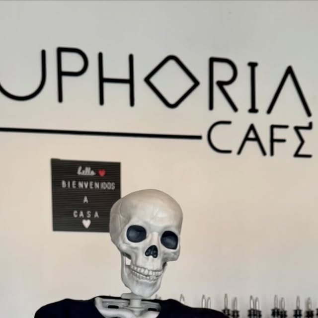 Esqueleto de Halloween frente al letrero de Euphoria Café