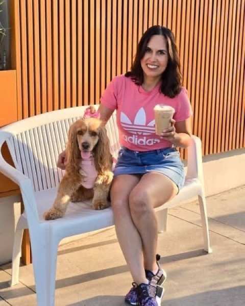 Clienta con su cocker spaniel y un café en la banca de la fachada