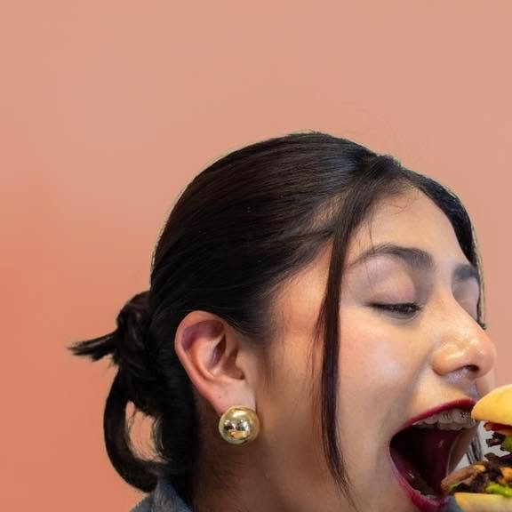 Publicación: chica a punto de morder una hamburguesa