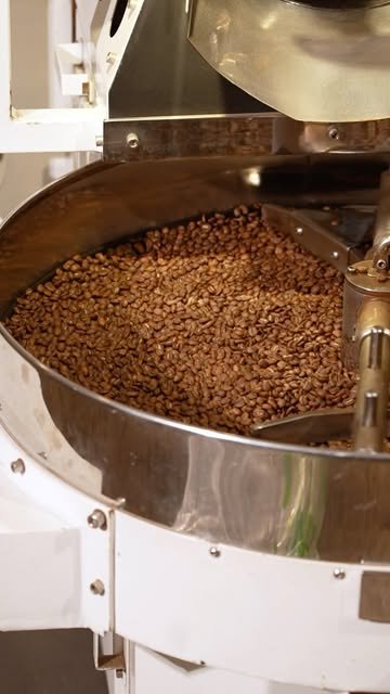 Granos de café recién tostados girando en el enfriador de la tostadora