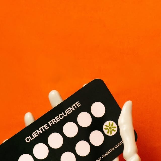 Mano de esqueleto sosteniendo la tarjeta de cliente frecuente