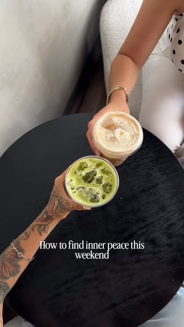 Matcha frío y latte con foam brindando sobre una mesa negra
