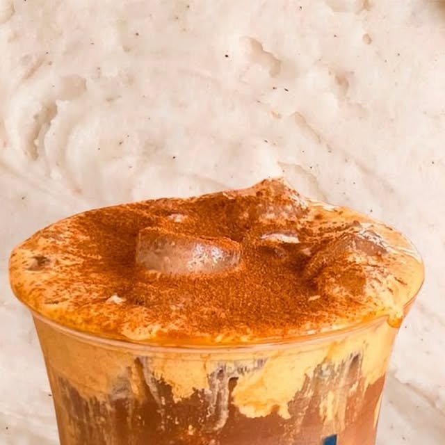 Pumpkin spice helado con espuma naranja y canela espolvoreada en vaso Revel