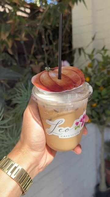 Pumpkin spice helado en vaso de Leo Cafetería con una calabaza de papel encima, en el jardín