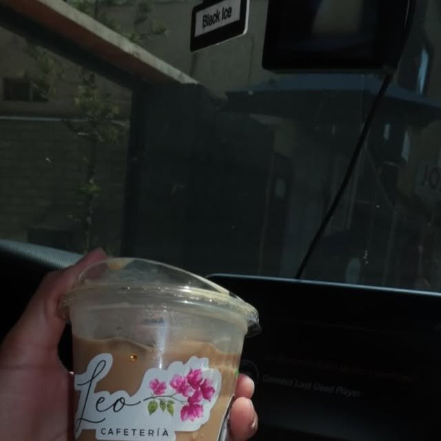 Café helado en vaso de Leo Cafetería con bugambilias impresas, de camino en el carro